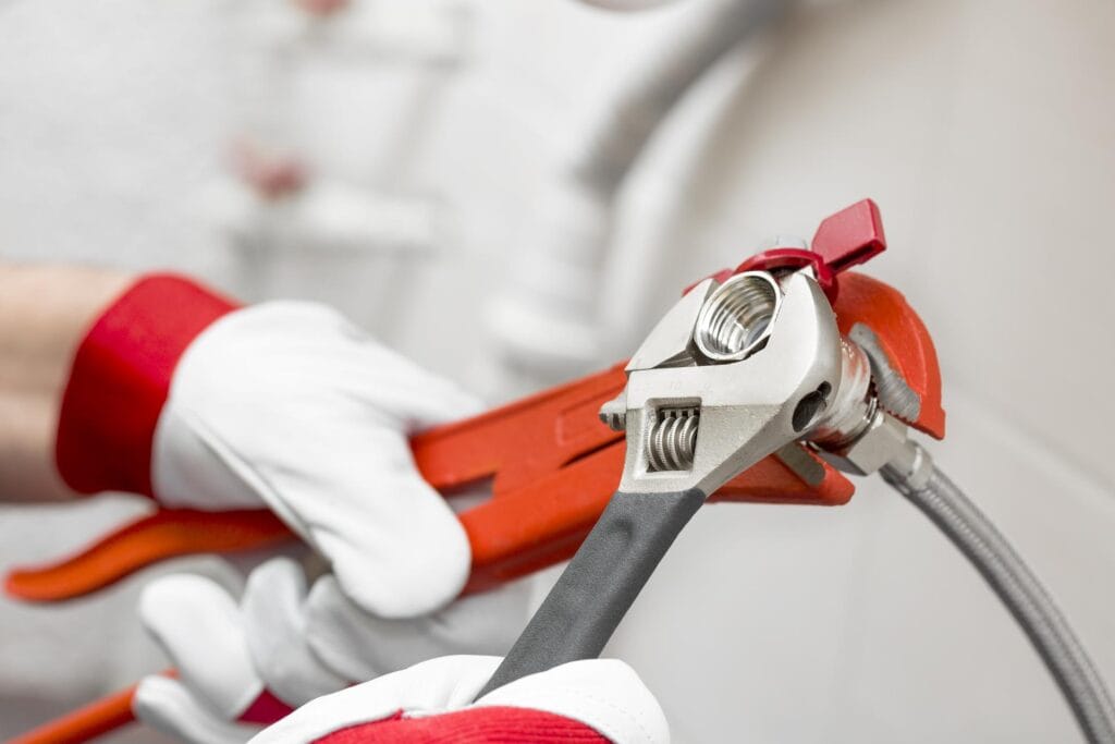 Plumber tightening pipe fitting for residential plumbing repair in Boynton Beach, Florida