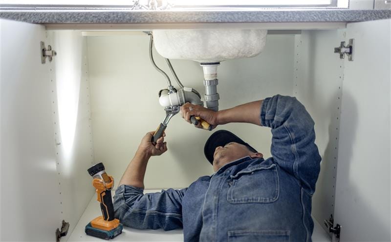 Plumber repairing kitchen sink drain pipes in Boynton Beach, Florida